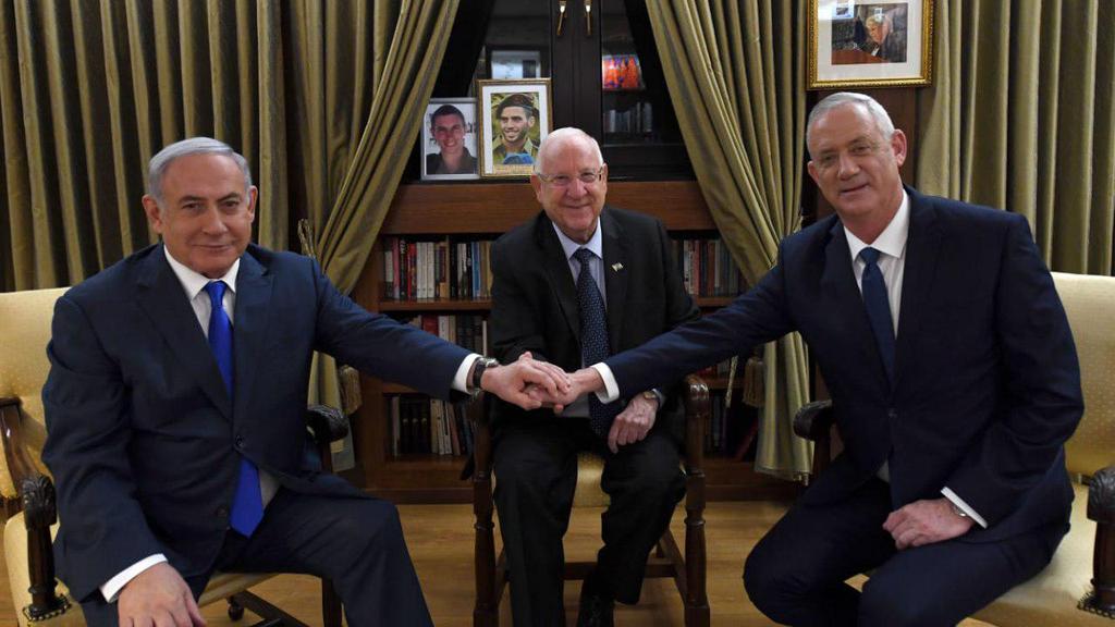 Benjamin Netanyahu and Benny Gantz clasp hands with President Reuven Rivlin during the first round of efforts to form a unity government (Photo: GPO) בנימין נתניהו ראובן ריבלין בני גנץ