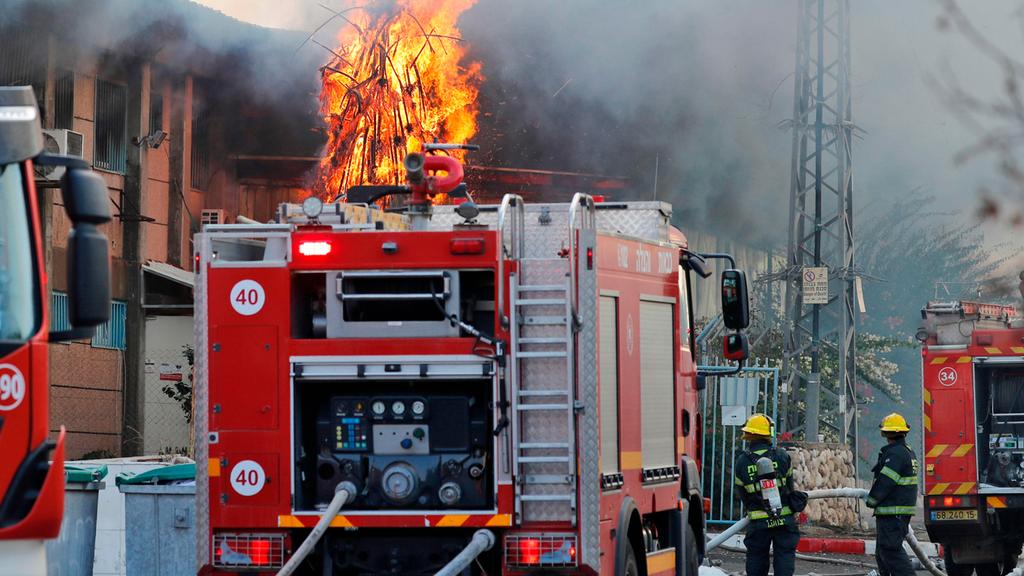 Sderot firefighters battle a blaze caused by Gaza rocket fire (Photo: AFP) בעקבות ההסלמה וירי הרקטות מעזה: פגיעה במפעל בשדרות