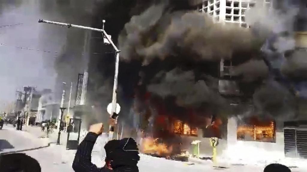 Iranian protesters set fire to a bank in Bahbahan, southwest Iran during a demonstration against an increase in gasoline prices