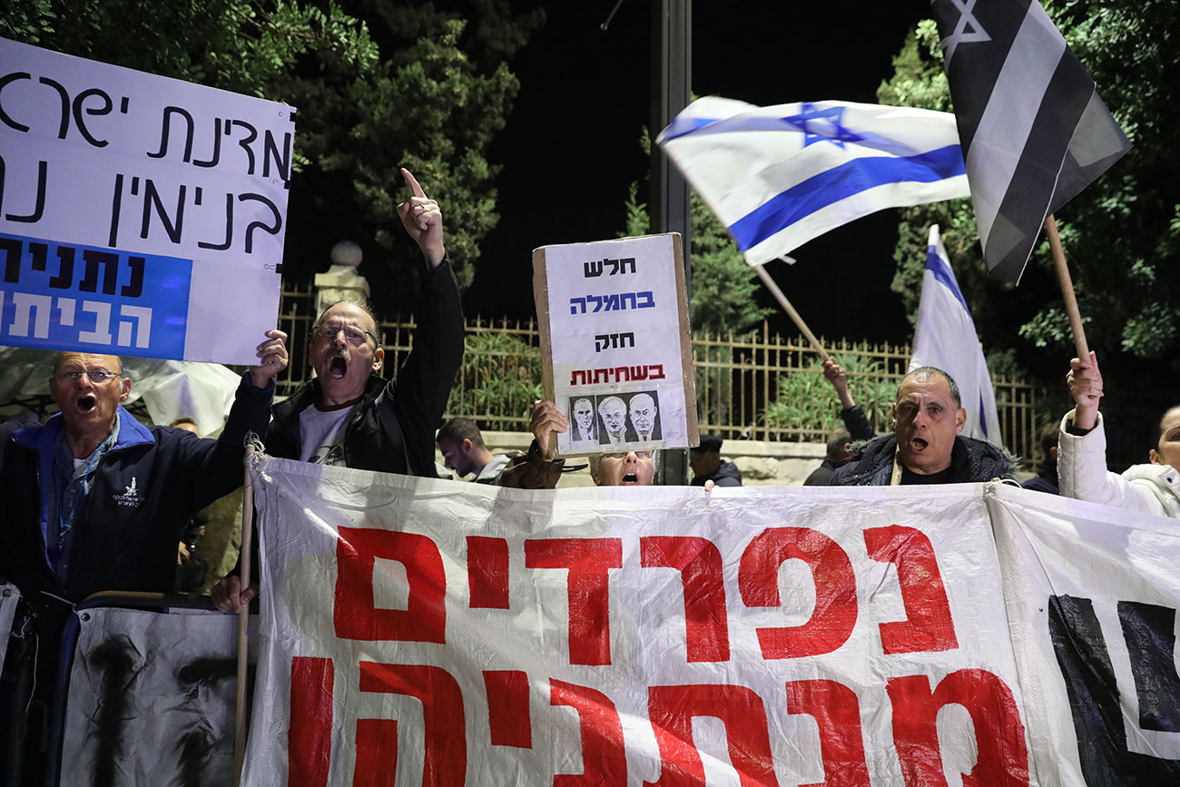 A protest against Benjamin Netanyahu in Jerusalem after charges were announced Thursday. The banner in red reads: Parting from Netanyahu (Photo: EPA) הפגנה נגד בנימין נתניהו במעון בבלפור