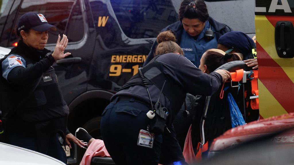 Police helping the wounded at the scene of the shooting (Photo: AFP) ירי ברחוב מרטין לוטר קינג' בניו גרזי