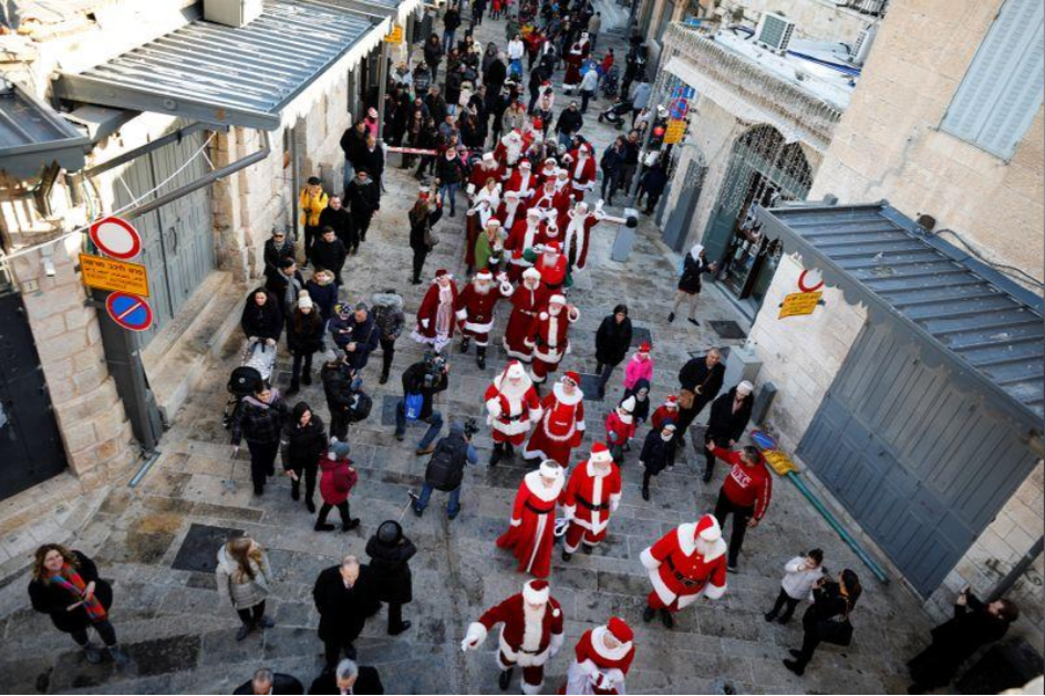 A group of Santa Clauses parading through the Old City 