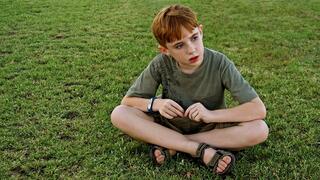 ילד אוטיסט בוהה בדשא 