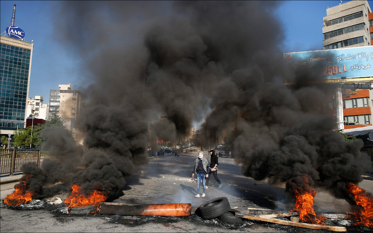 Anti-government protesters burn tires during ongoing protests after weeks of calm in Beirut 