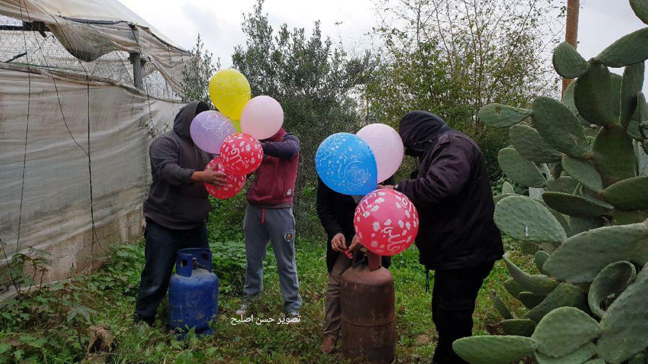 Palestinian terrorists prepare to launch balloon bombs from Gaza into Israel