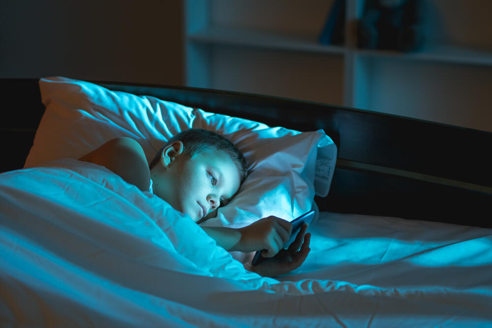 ילד מתכונן לשינה עם טלפון חכם