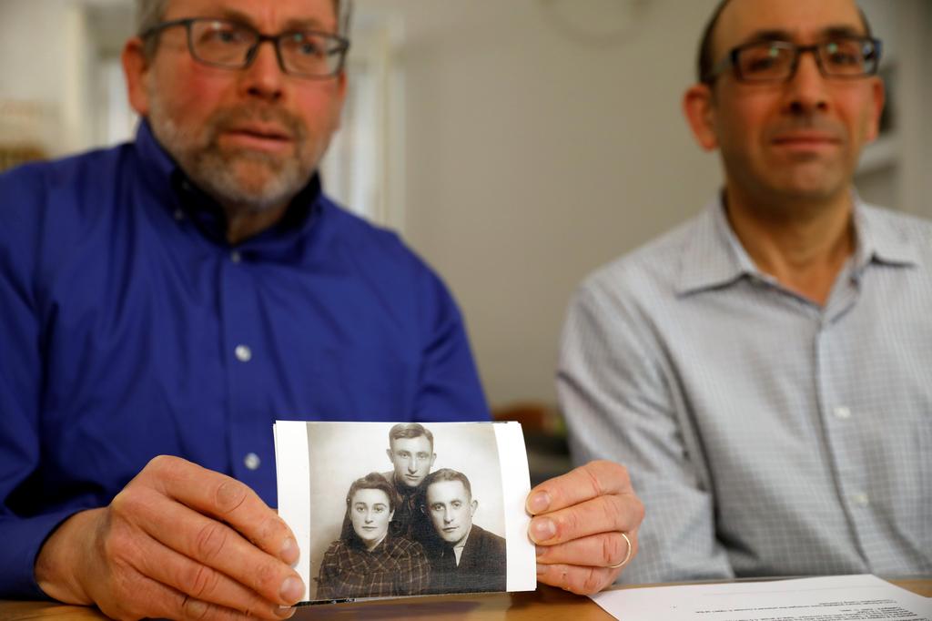 Eli and Saul Lieberman show a photograph of their late father Joseph (top), a survivor of the Nazi death camp Auschwitz, taken several years after the Holocaust 