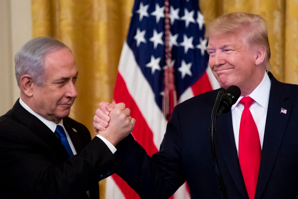 Benjamin Netanyahu clasps hands with Donald Trump as the U.S. president unveils his Mideast peace plan at the White House (Photo: EPA) הבית הלבן