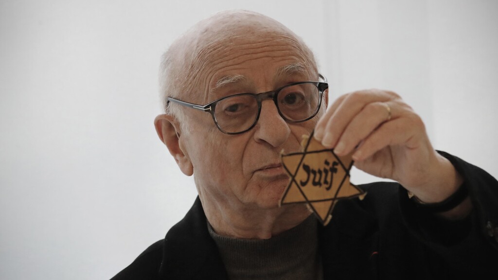Victor Perahia, who survived the Holocaust as a child, shows a yellow star worn by Jews in Nazi-occupied areas during a workshop at the Drancy Shoah memorial, Jan. 30, 2020 
