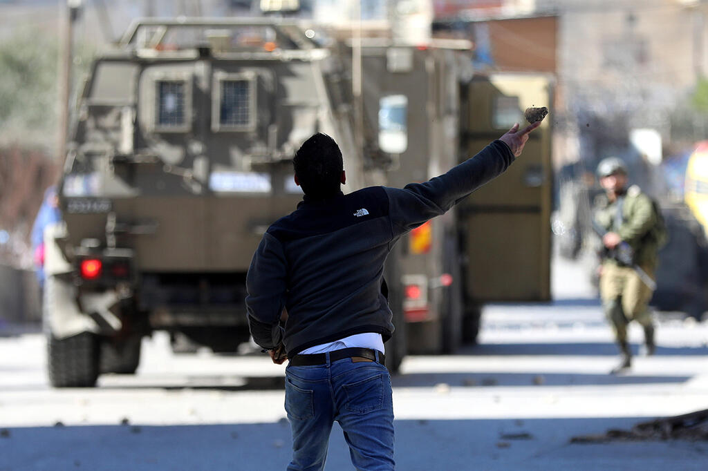 Palestinians confronting IDF soldiers in Hebron (Photo: EPA) פלסטינים מיידים אבנים על רכבי צה