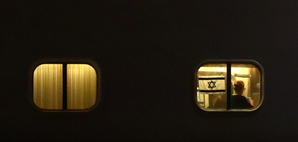 An Israeli flag is seen in a window of the Diamond Princess (Photo: AFP) דגל ישראל ב ספינה דיימונד פרינסס קורונה נגיף יפן