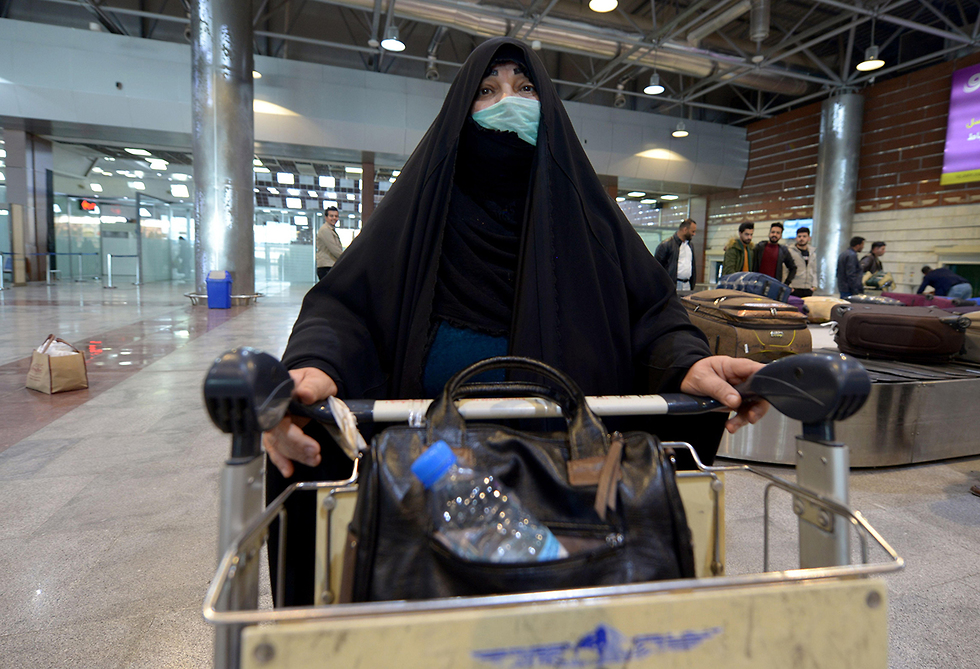 An Iranian entering the country via the border crossing with Iraq (Photo: AFP ) אנשים נכנסים ל עיראק חוזרים מ איראן נעם מסכות נגיף קורונה