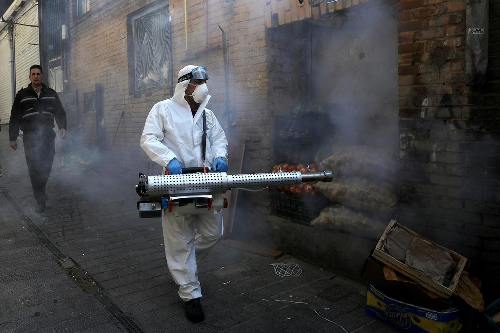 Iranian health worker disinfecting a Tehran street (Photo: AP) חיטוי באיראן
