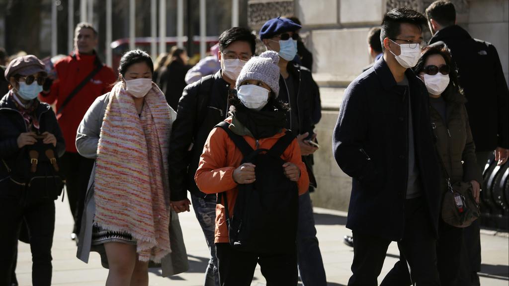 People walking in London with surgical masks (Photo: AP) אנשים