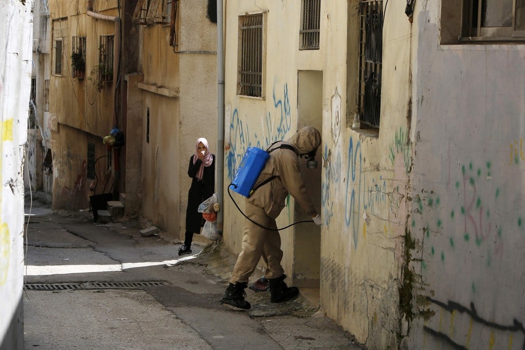 A Palestinian health worker disinfecting a house in Bethlehem (Photo: AFP) התפשטות הקורונה בקרב הפלסטינים