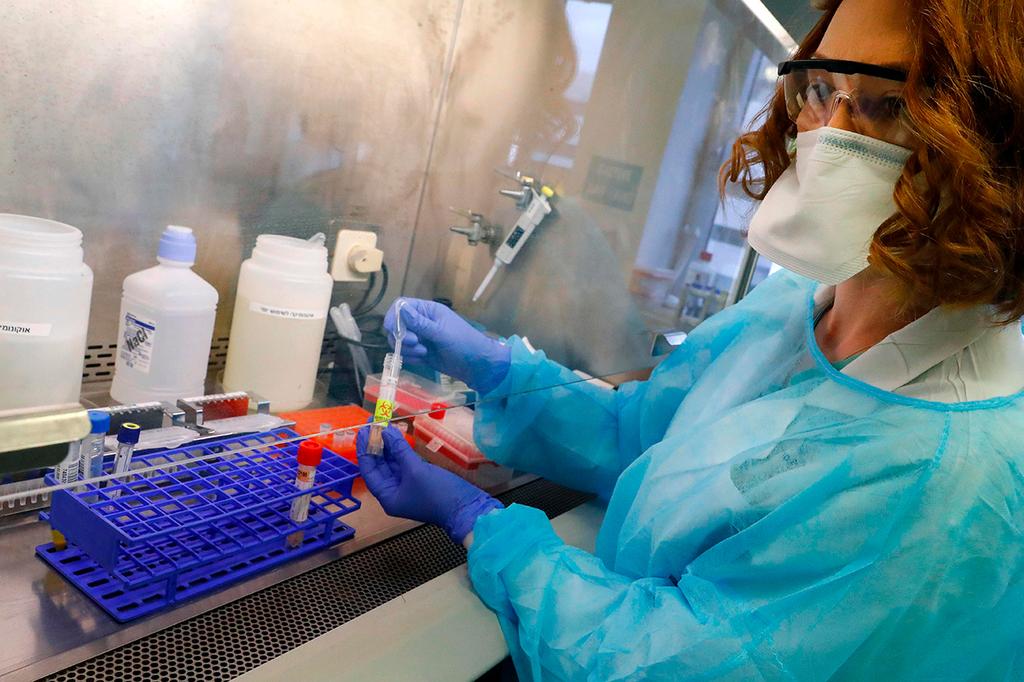 Illustrative: A coronavirus research lab at Ichilov Hospital in Tel Aviv (Photo: AFP) בדיקות נגיף קורונה מבחנה מעבדה בית חולים איכילוב תל אביב