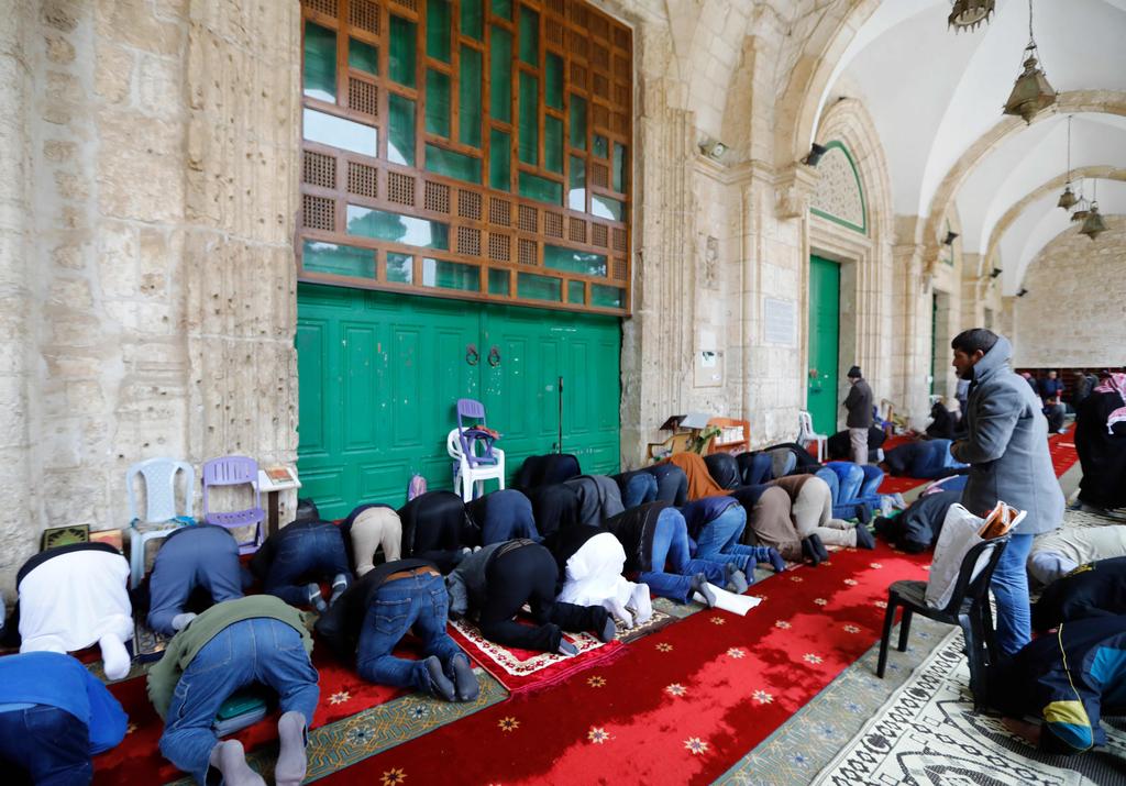 Muslims gather to perform Friday prayers in front of the closed   doors of Al-Aqsa mosque in Jerusalem's Old City, after the mosque   and Dome of the Rock were shut, March 20, 2020 