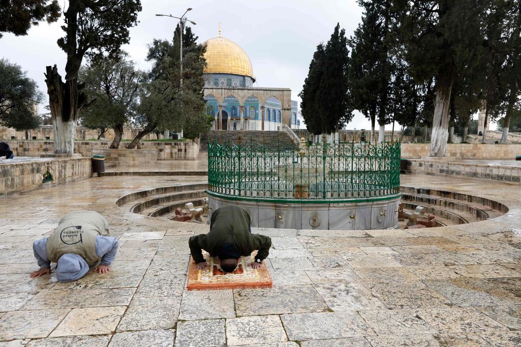 Palestinians perform their Friday prayers in the almost deserted   Al-Aqsa mosque compound in the Old City of Jerusalem, after the   mosques were shut in a bid to stem the spread of coronavirus,   March 20, 2020 
