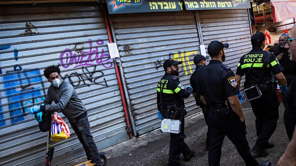 Police officers closing down Tel Aviv's Carmel Market in March (Photo: AP) שוק הכרמל