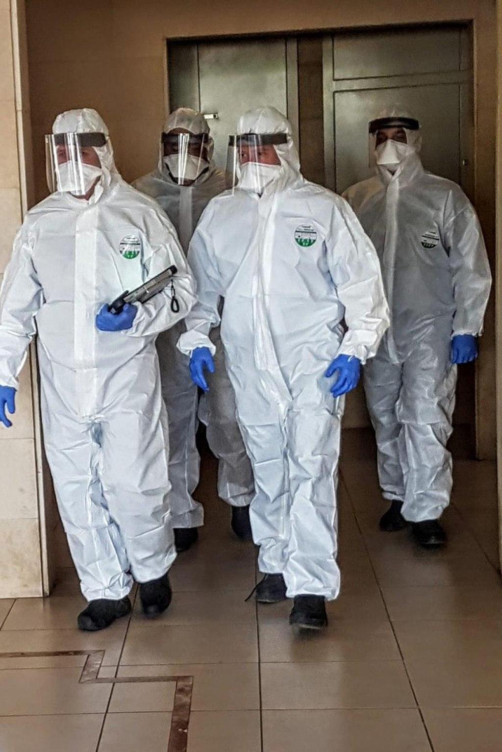 Police officers in hazmat suits in Tel Aviv amid coronavirus pandemic (Photo: The Health Ministry ) פקחים של משטרת ישראל ומשרד הבריאות אוכפים הפרה של בידוד ביתי