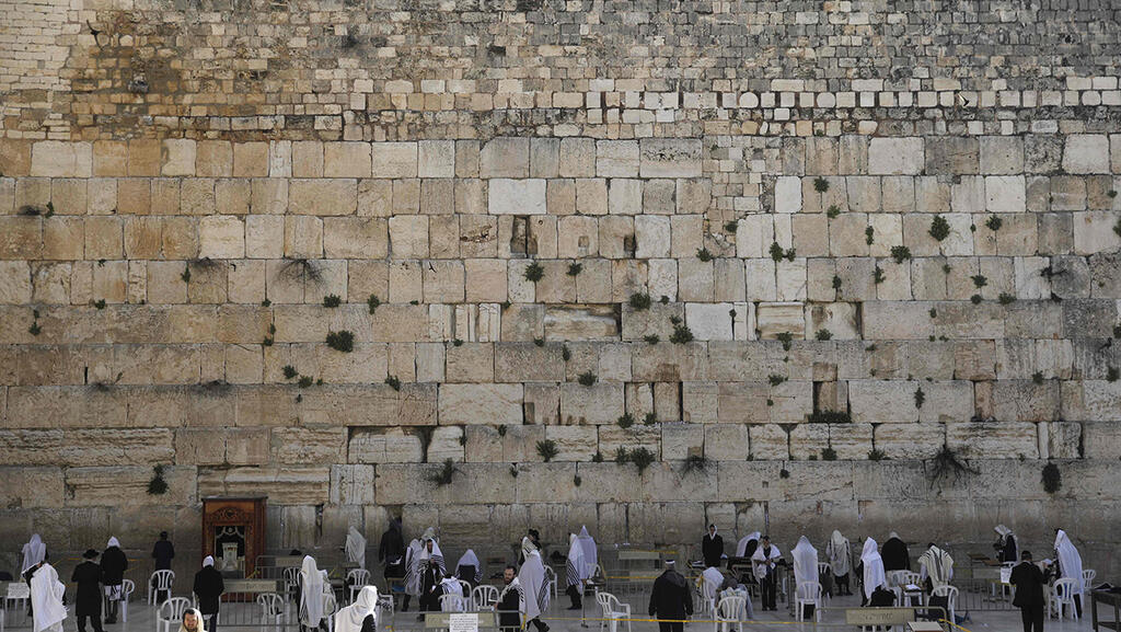 הדרת נשים בכותל המערבי (ארכיון) (צילום: AFP) מתפללים בכותל בירושלים שומרים מרחק אחד מהשני