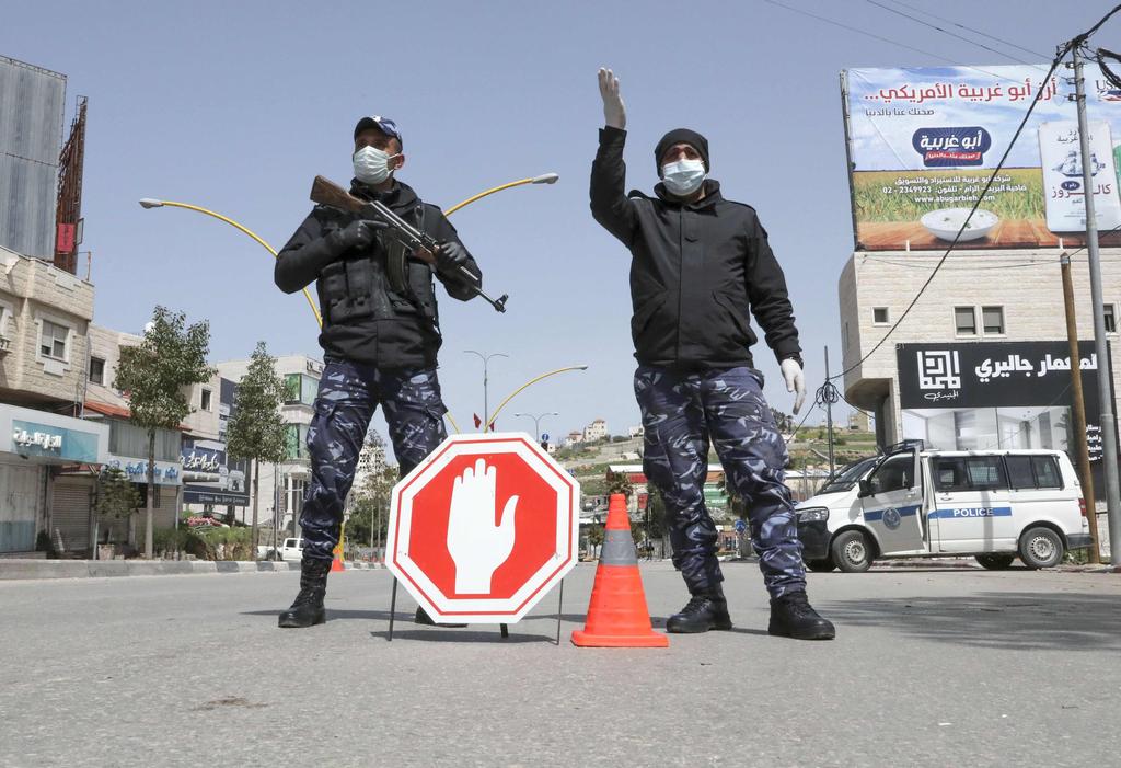 Palestinian security forces man a checkpoint to control movement on a main entrance to the city of Hebron in the West Bank amid efforts to curb the spread of the COVID-19 (Photo: AFP) Palestinian security forces man a checkpoint to control movement on a main entrance to the city of Hebron in the West Bank amid efforts to curb the spread of the COVID-19