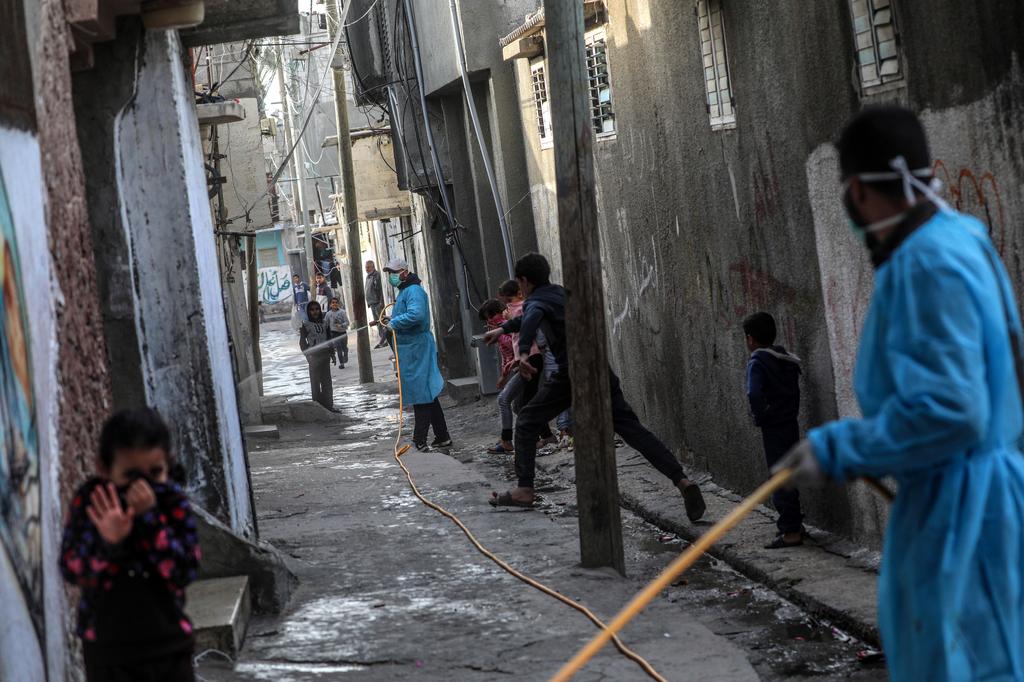 Palestinians spray disinfectant as a precaution against the spread of the Covid-19 coronavirus, in the streets of Al Nusairat refugee camp, central Gaza Strip (Photo: EPA) Palestinians spray disinfectant as a precaution against the spread of the Covid-19 coronavirus, in the streets of Al Nusairat refugee camp, central Gaza Strip