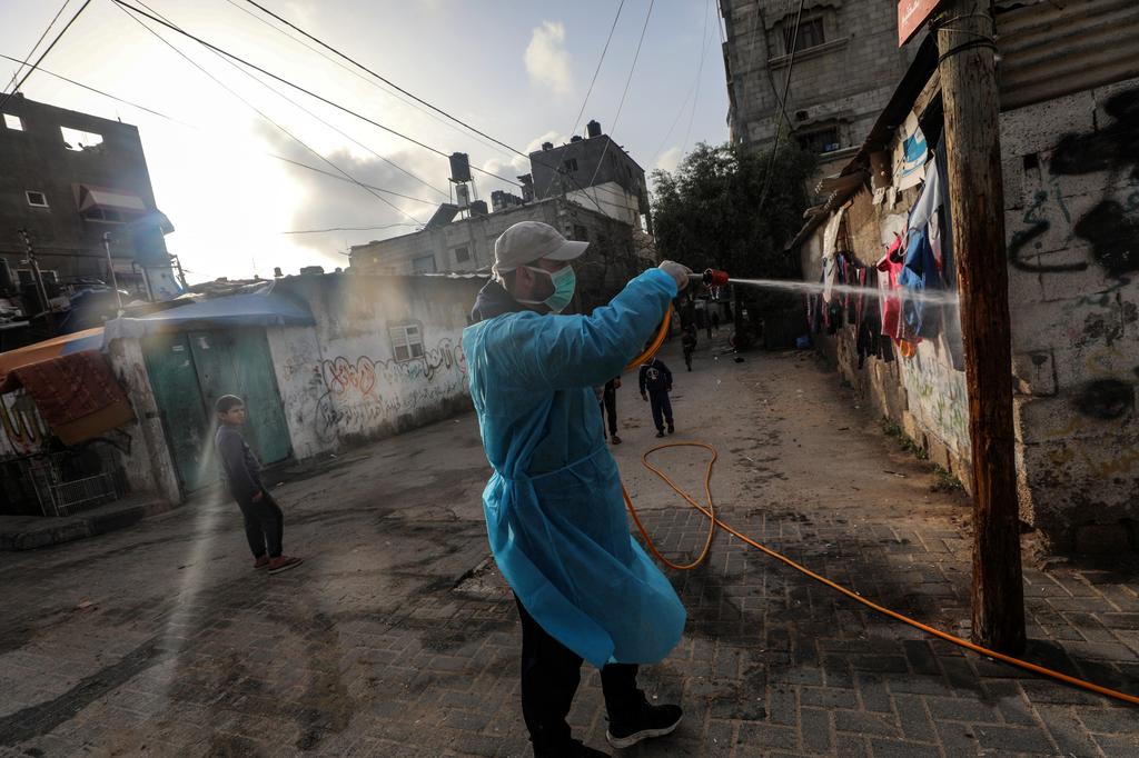 Palestinians spray disinfectant as a precaution against the spread of the Covid-19 coronavirus, in the streets of Al Nusairat refugee camp, central Gaza Strip (Photo: EPA) Palestinians spray disinfectant as a precaution against the spread of the Covid-19 coronavirus, in the streets of Al Nusairat refugee camp, central Gaza Strip