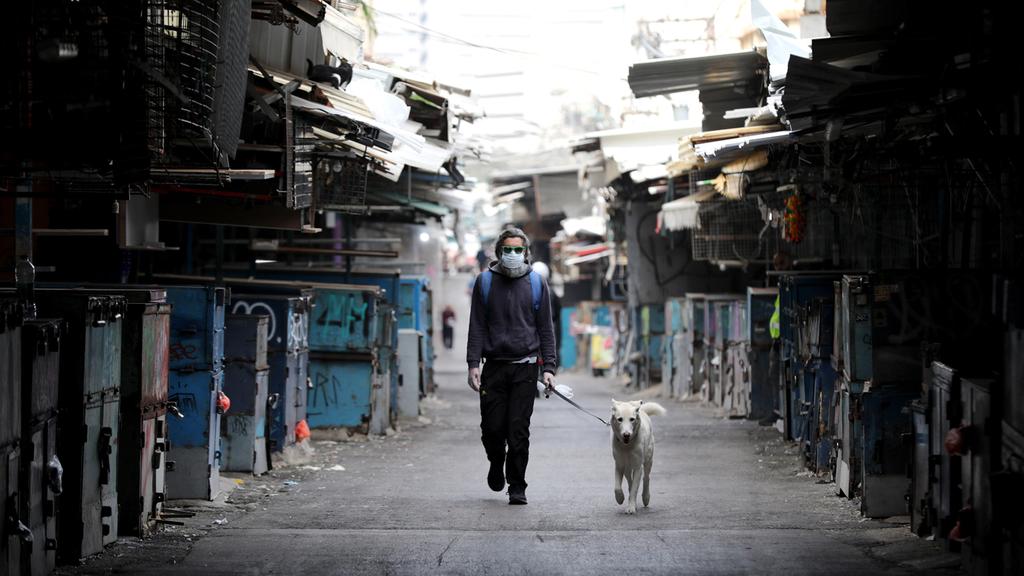 A man walks past the shuttered stalls in Tel Aviv's normally bustling Carmel Market (Photo: EPA) A man walks past the shuttered stalls in Tel Aviv's normally bustling Carmel Market