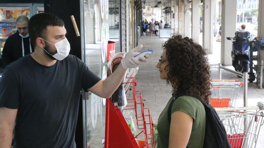 מדידת חום בכניסה לסופר. ארכיון (צילום: מוטי קמחי) שמירה על הנחיות משרד הבריאות בסופר בתל אביב