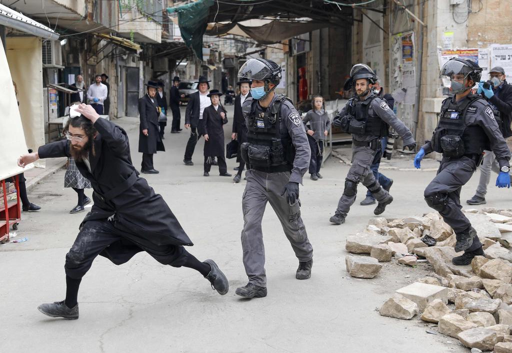 Israeli security forces arrest an Ultra Orthodox Jewish man as they close a synagogue in the Mea Shearim Ultra-Orthodox neighbourhood in Jerusalem, amid efforts to curb the spread of the COVID-19 coronavirus pandemic.