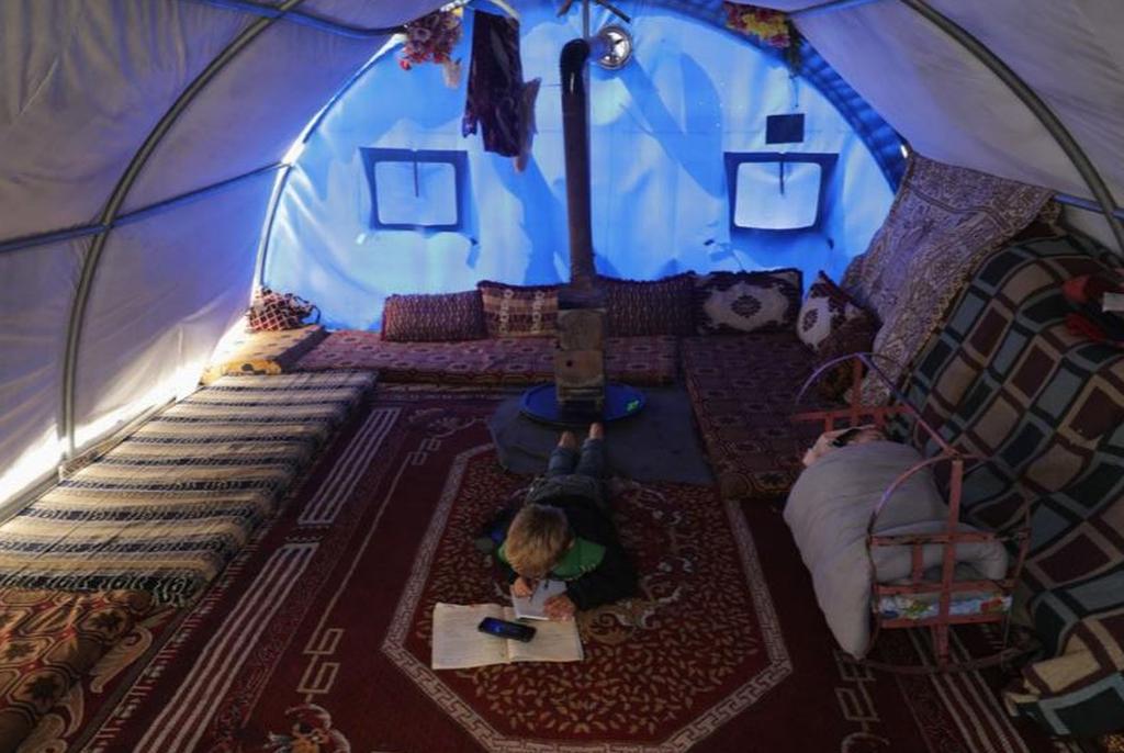 Mahmoud Abdel Hadi, 8, does his homework remotely in Atmeh camp after his tented school was shut due to the coronavirus threat (Photo: Reuters) 8 year old boy does his homework after his tented school was shut down