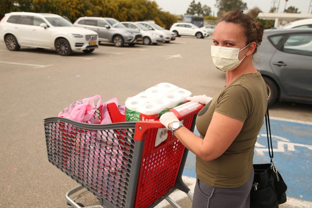 An Israeli woman wears a protective mask while shopping (Photo: Elad Gershgoren) אופנה