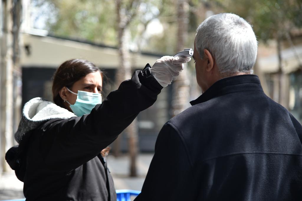 Woman checking temperature - one of coronavirus' main symptoms (Photo: Yoav Dudkevitch) עמדת בידוק חום