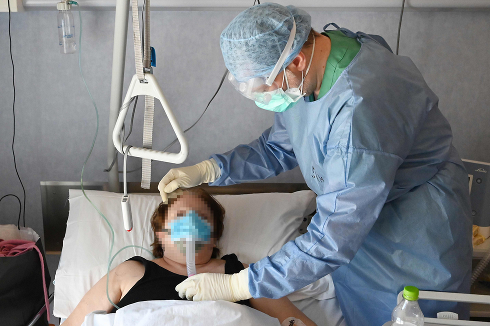 Caring for a coronavirus patient in Rome (Photo: AFP) מסכות נגד קורונה צוותי רפואה בית חולים רומא איטליה
