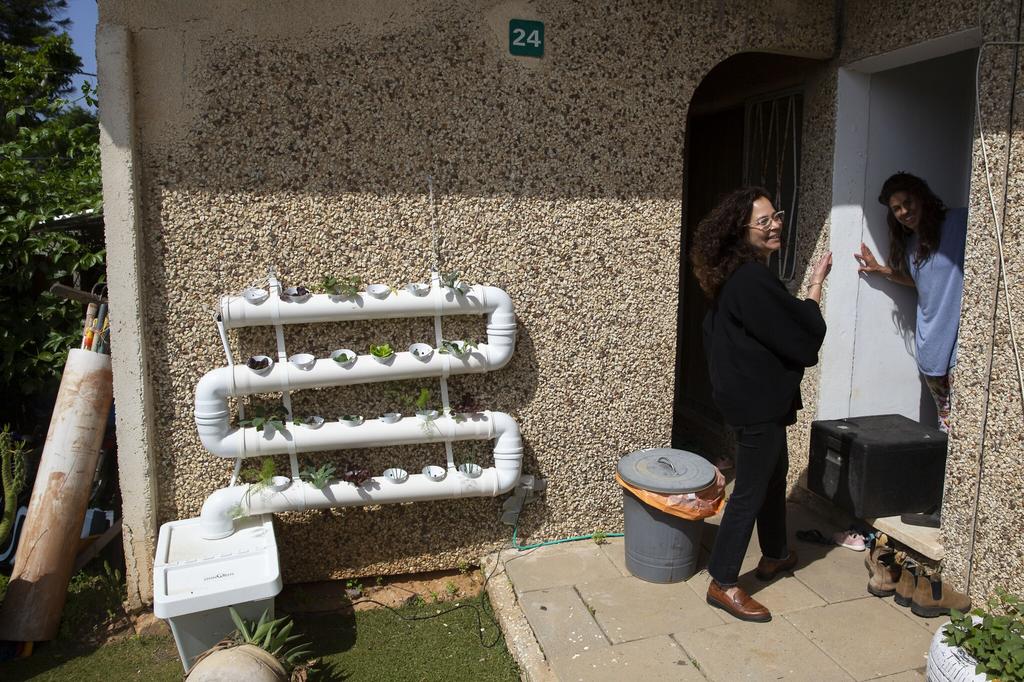 Volunteer Einat Kedem, left, speaks with emergency room doctor Maayan Bacher after delivering her a home-cooked meal 