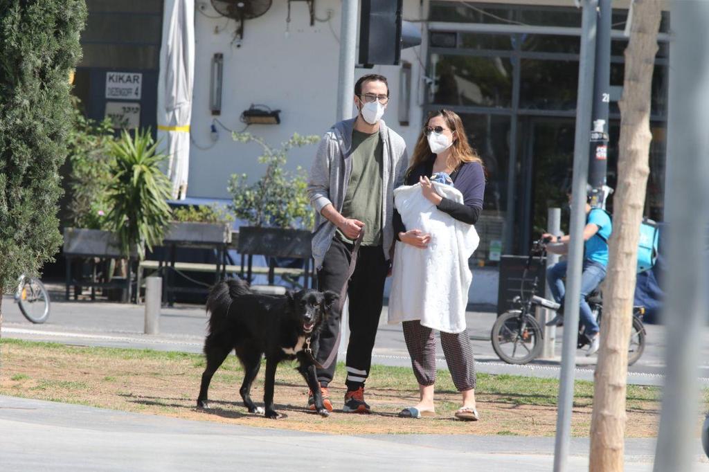 An Israeli couple wearing masks against coronavirus in Tel Aviv (Photo: Moti Kimchi) אנשים מטיילים ב תל אביב
