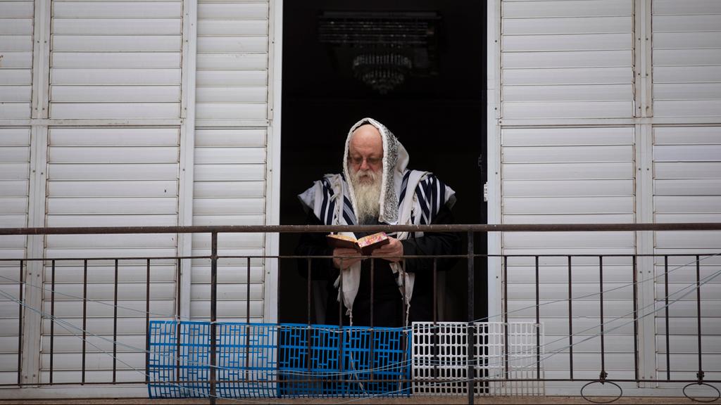  An elderly man looks out the window amid lockdown 