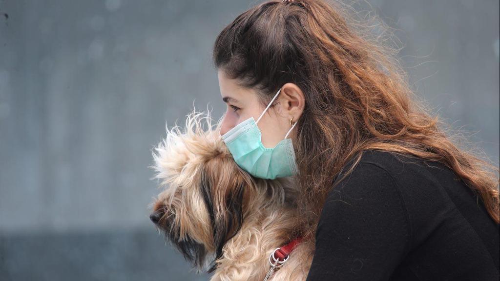 A woman hugs her dog in Tel Aviv amid the coronavirus crisis (Photo: Moti Kimchi) הציבור מטייל ביום שמשי בכיכר דיזנגוף למרות הקורונה