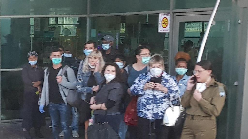 People ignoring social distancing at a bus stop in Haifa (Photo: Simcha Danilov) נוסעים ממתינים ברציף התחנה המרכזית בחיפה