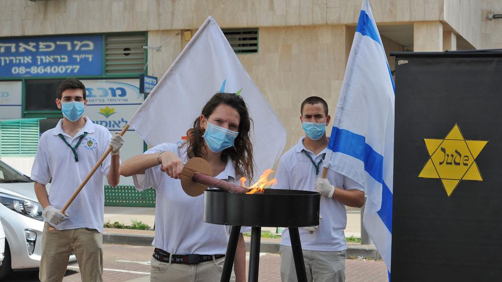 High school students holding a memorial ceremony outside a nursing home in Ashkelon (Photo: Avi Rokah ) התלמידים יזמו: טקס יום השואה ברחוב מול חלון חדרם של ניצולי שואה שנמצאים בבית אבות