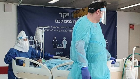 Medical professionals attend a coronavirus patient at Ichilov Hospital in Tel Aviv (Photo: Zlila Helman) Medics in protective gear against coronavirus with a patient at Ichilov Hospital in Tel Aviv
