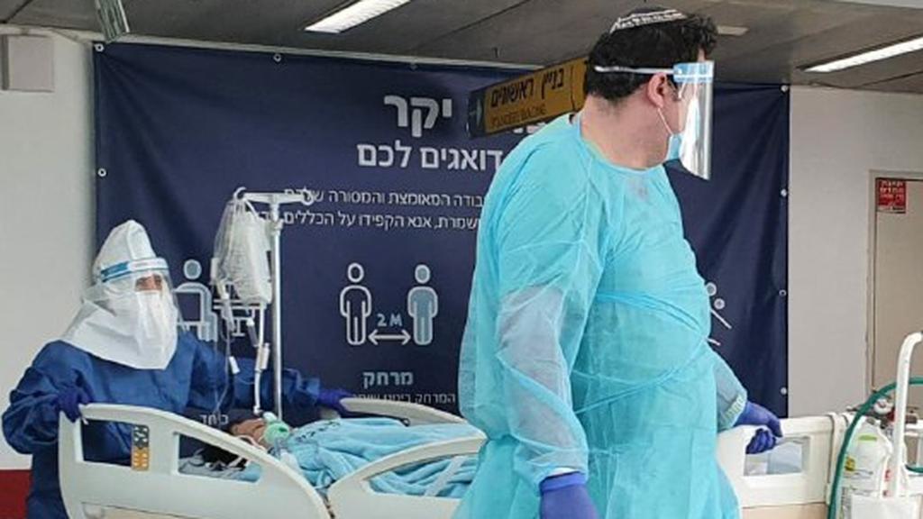 Medics in protective gear against coronavirus with a patient at Ichilov Hospital in Tel Aviv  
