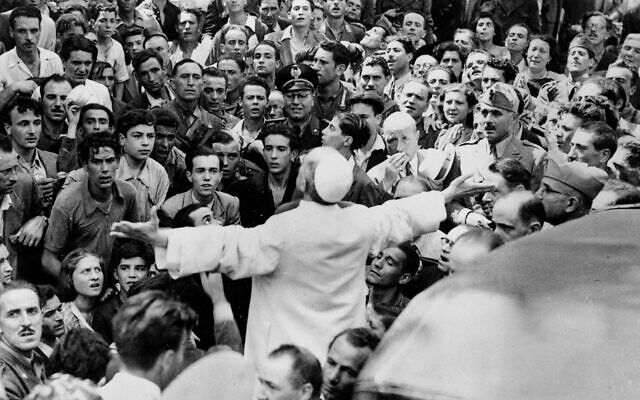 Men, women and soldiers gather around Pope Pius XII, his arms outstretched, on Oct. 15, 1943, during his inspection tour of Rome, Italy 