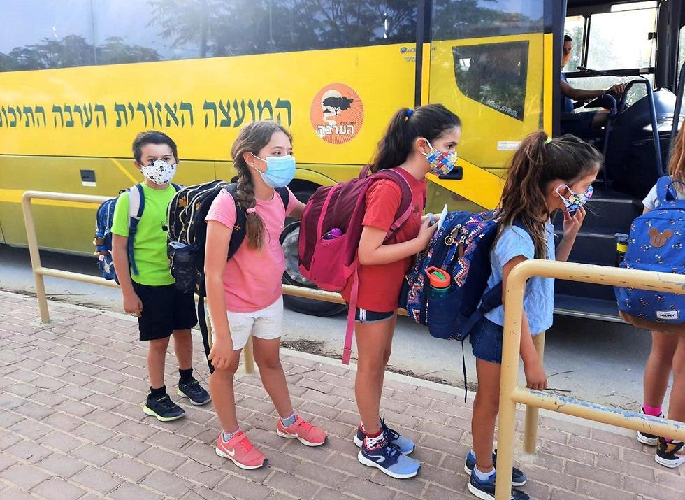 תלמידים עולים לאוטובוס במועצה אזורית הערבה התיכונה, במאי אשתקד. המועצות דורשות הבחנה ברמזור בין יישוב ליישוב (צילום: מירית הלמן, הערבה התיכונה) יום ראשון לחזרה ללימודים בבית הספר 'שיטים' במועצה אזורית הערבה התיכונה