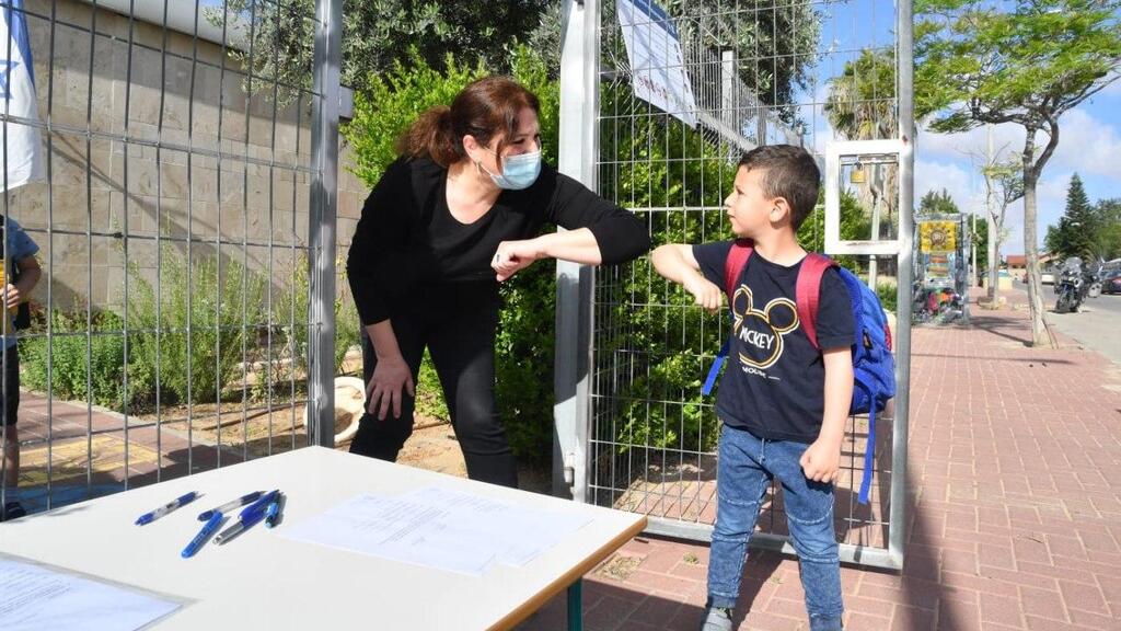 A kindergarten teacher in Ofakim welcomes a child back after the reopening of the education system (Photo: Haim Hornstein) חזרה לגנים באופקים: גן כלנית