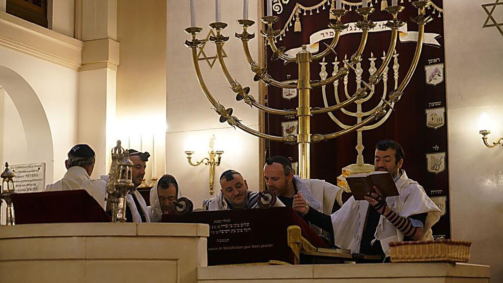 הרב מיכאל אזולאי, שני מימין, קורא בתורה עם אנשי הקהילה בבית הכנסת בניי-סור-סן, פרבר של פריז, ב-11 בדצמבר 2017