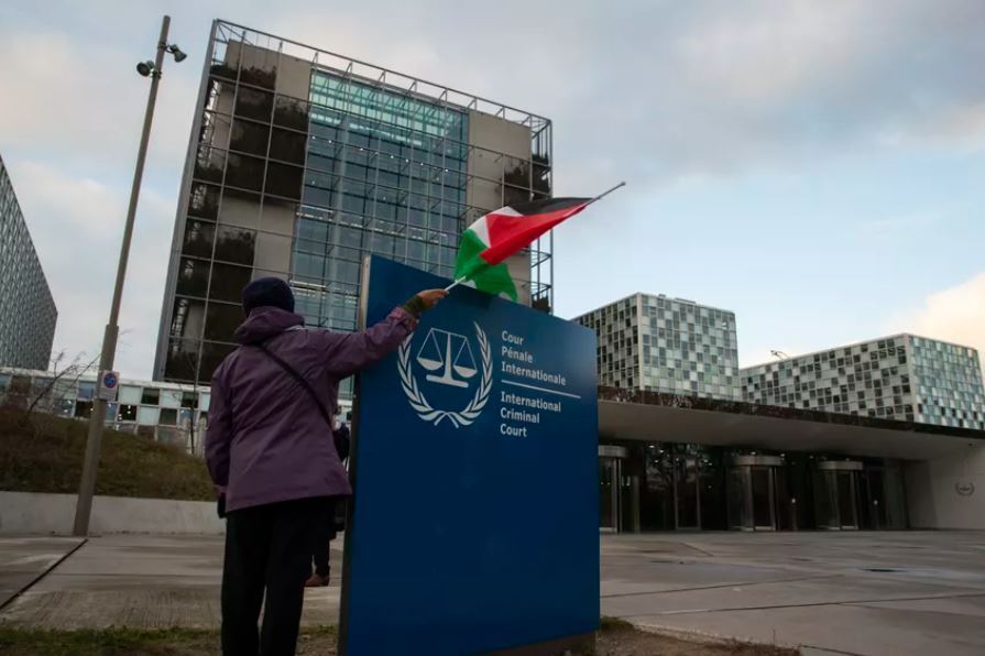 A demonstrator poses with a Palestinian flag outside the International Criminal Court