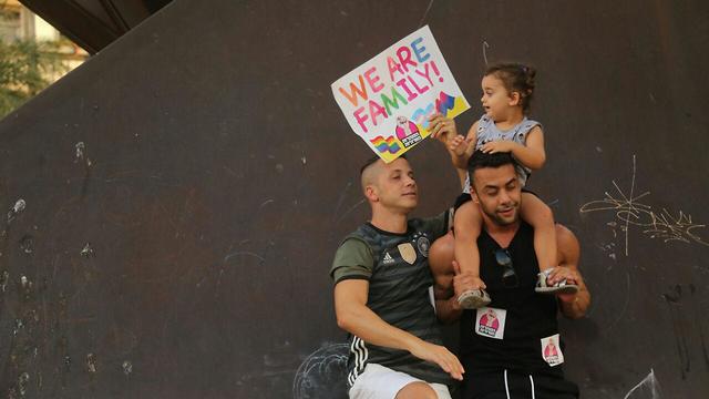 A gay couple and their daughter at a July 2019 protest in Tel Aviv against the surrogacy ban for same-sex partners 