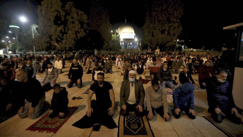 Muslim men pray next to the Dome of the Rock Mosque in the Al Aqsa Mosque compound in Jerusalem's old city, Sunday, May 31, 2020 